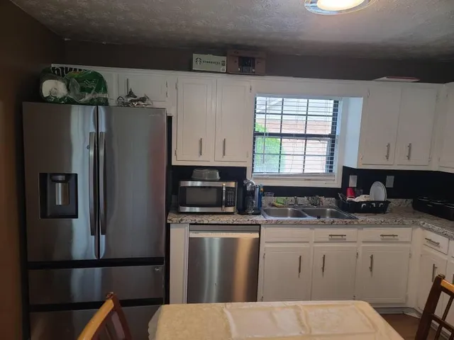 a kitchen with stainless steel appliances granite countertop a refrigerator sink and stove