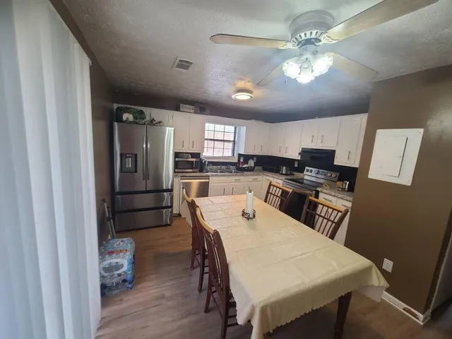 a kitchen with refrigerator a stove and chairs