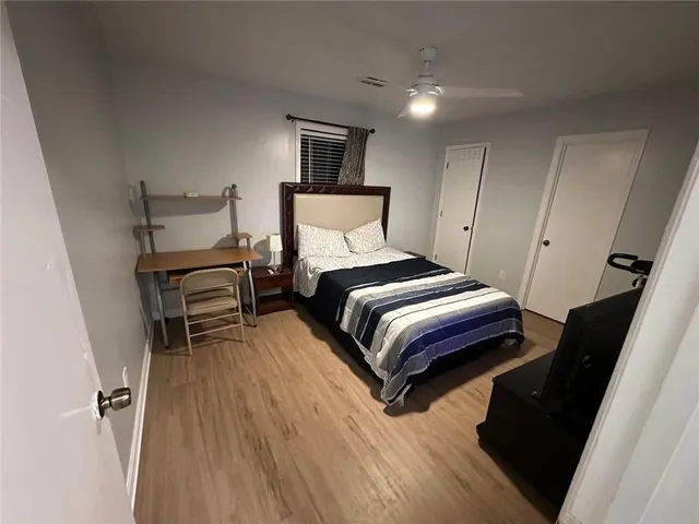 a bedroom with a bed and wooden floor