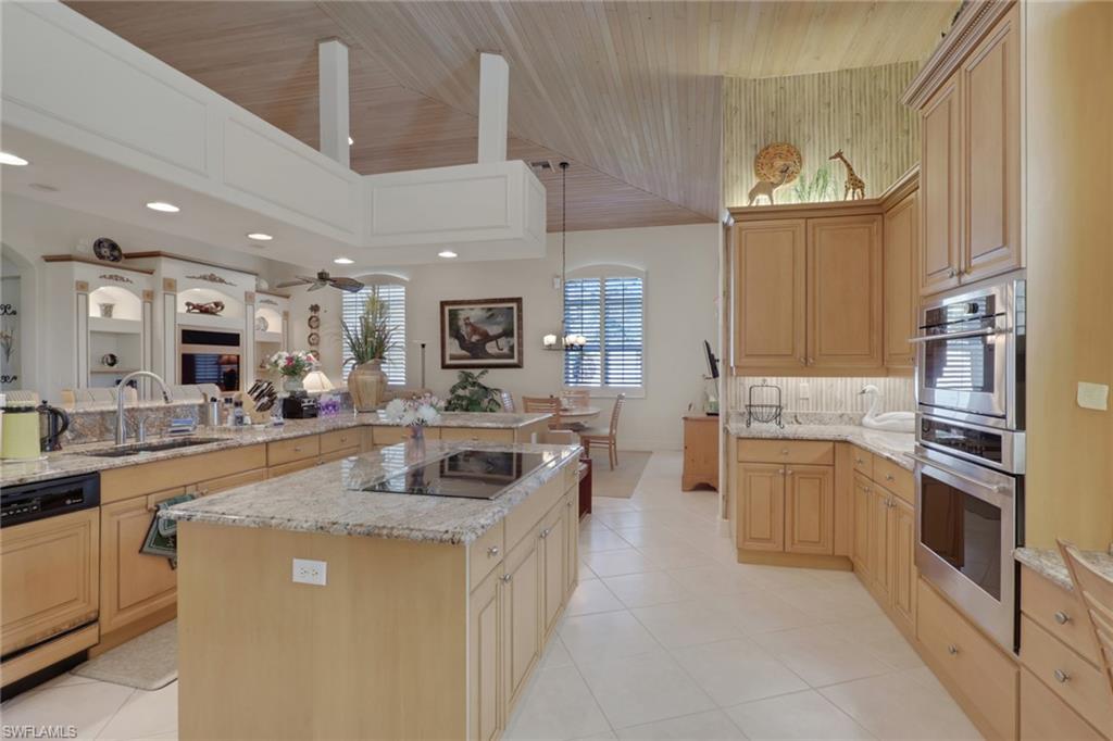 435 Terracina Way Naples, FL 34119 - Photo 18 of 50 a kitchen with stainless steel appliances granite countertop a sink and a refrigerator