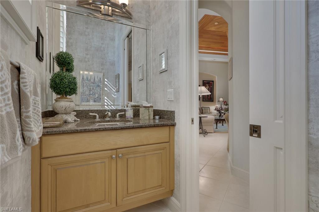 435 Terracina Way Naples, FL 34119 - Photo 22 of 50 a en suite bathroom with a granite countertop sink and a mirror