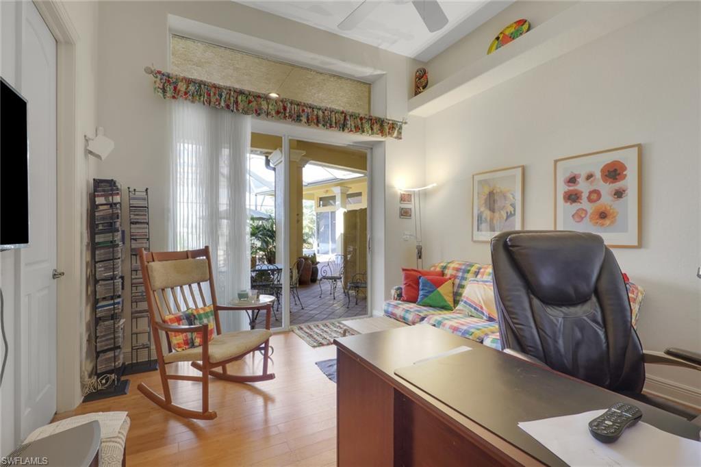 435 Terracina Way Naples, FL 34119 - Photo 26 of 50 a living room with furniture and a book shelf