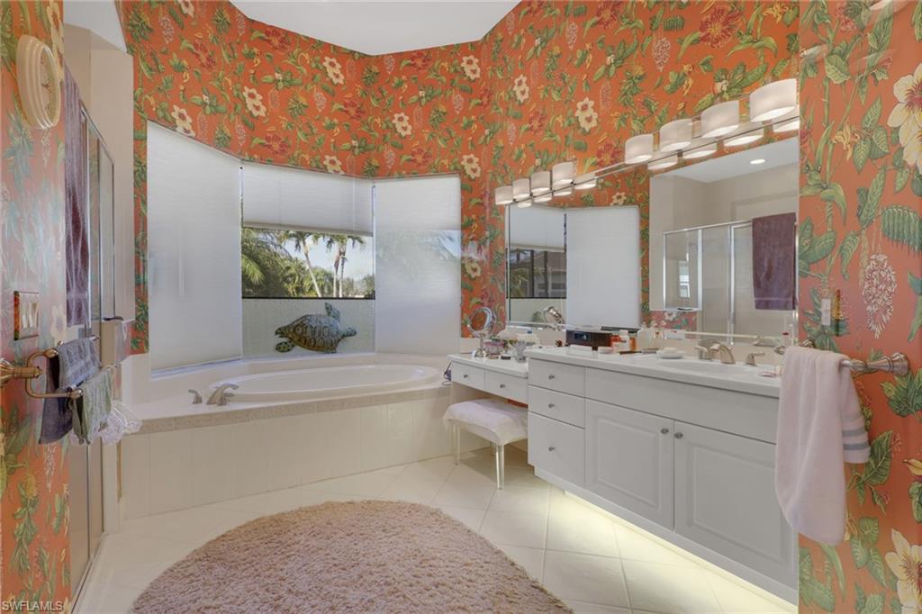 435 Terracina Way Naples, FL 34119 - Photo 28 of 50 a bathroom with a tub sink and mirror