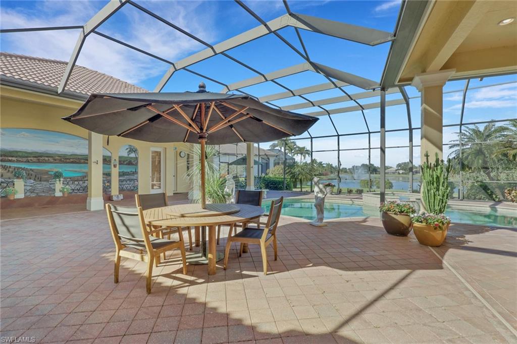 435 Terracina Way Naples, FL 34119 - Photo 34 of 50 a view of a patio with table and chairs under an umbrella