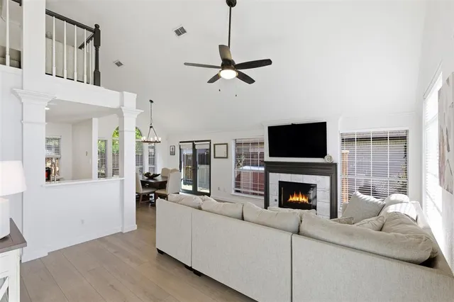 a living room with furniture a flat screen tv and a fireplace