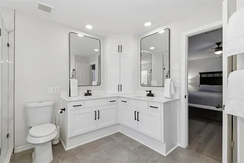 a spacious bathroom with a double vanity sink toilet and a tub