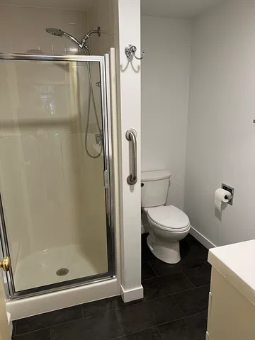 a bathroom with a toilet and a shower