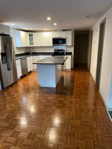 a kitchen with stainless steel appliances a stove a sink a microwave a refrigerator and cabinets