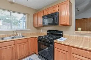a kitchen with stainless steel appliances granite countertop white cabinets and a stove top oven