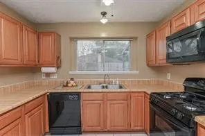 a kitchen with stainless steel appliances wooden cabinets and a stove top oven