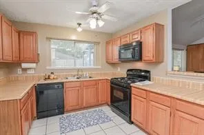a kitchen with stainless steel appliances granite countertop a sink stove cabinets and a window