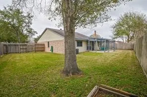a view of a house with backyard and a tree