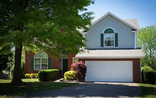 a front view of a house with a garden and plants