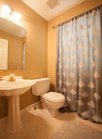 a bathroom with a sink a toilet and shower curtain