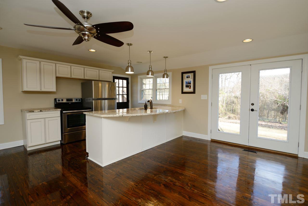 8300 Pinecrest Road Raleigh, NC 27613 - Photo 1 of 12 a kitchen with granite countertop stainless steel appliances cabinets and a wooden floor