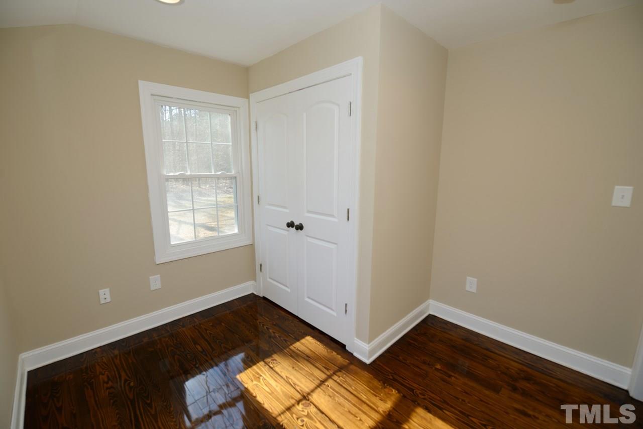 8300 Pinecrest Road Raleigh, NC 27613 - Photo 8 of 12 an empty room with wooden floor and windows