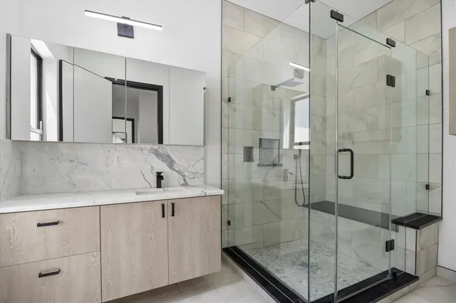 a bathroom with a shower sink and mirror