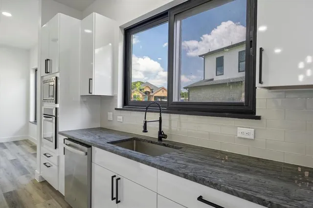 a kitchen with stainless steel appliances granite countertop a sink and a microwave
