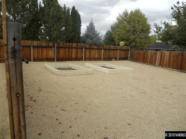 1055 Tapadero Trail Reno, NV 89521 - Photo 9 of 13 a view of a backyard with a barbeque and wooden fence