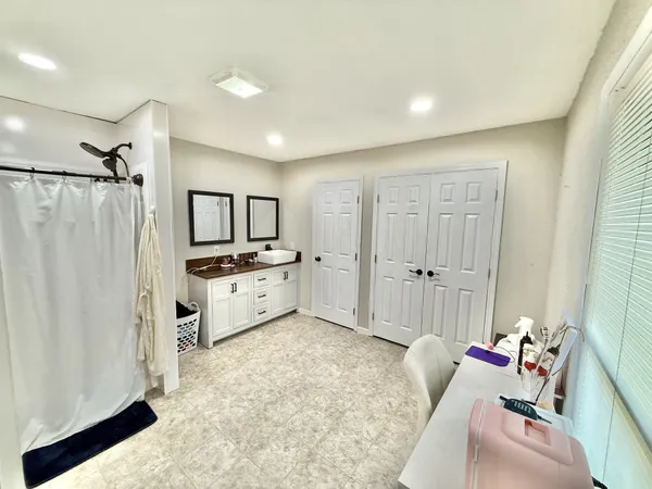 a large white room with a baby crib and a couch