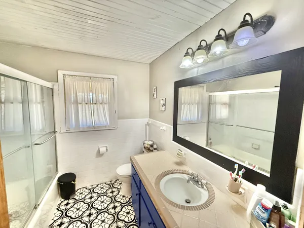 a bathroom with a sink a mirror and a shower