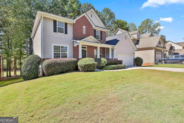a front view of a house with a yard and potted plants