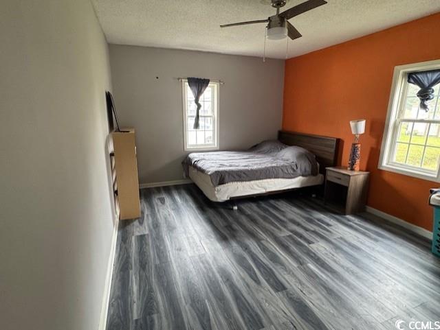 15 Mango Street Andrews, SC 29510 - Photo 12 of 26 Bedroom with dark wood-style flooring, a textured ceiling, and a ceiling fan