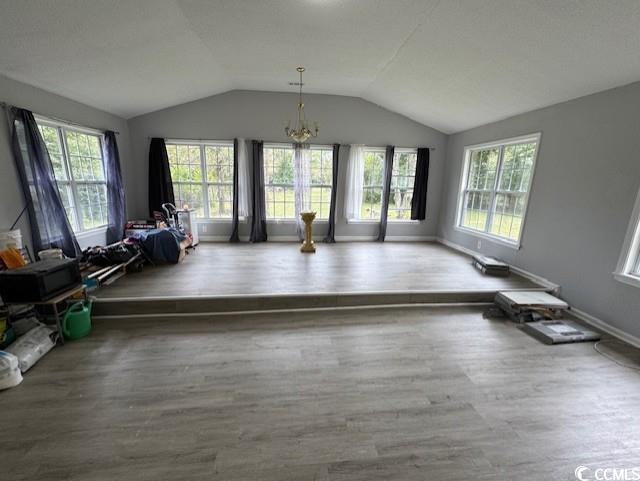 15 Mango Street Andrews, SC 29510 - Photo 18 of 26 Unfurnished living room with wood finished floors, a chandelier, and lofted ceiling