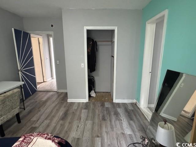 15 Mango Street Andrews, SC 29510 - Photo 9 of 26 Unfurnished bedroom featuring dark wood-style flooring and a walk in closet