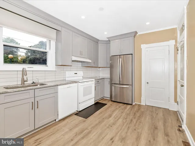 a kitchen with granite countertop white cabinets and white appliances