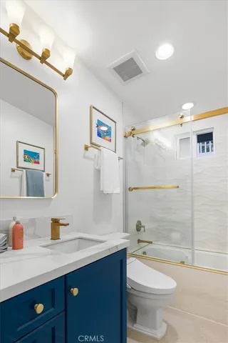 a bathroom with a granite countertop sink toilet and shower