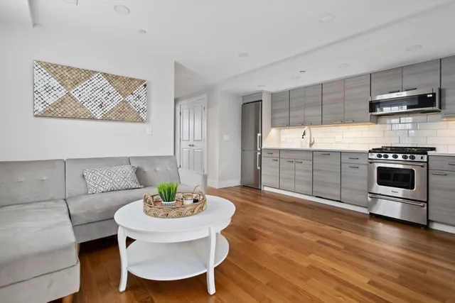 a kitchen with stainless steel appliances a dining table and chair