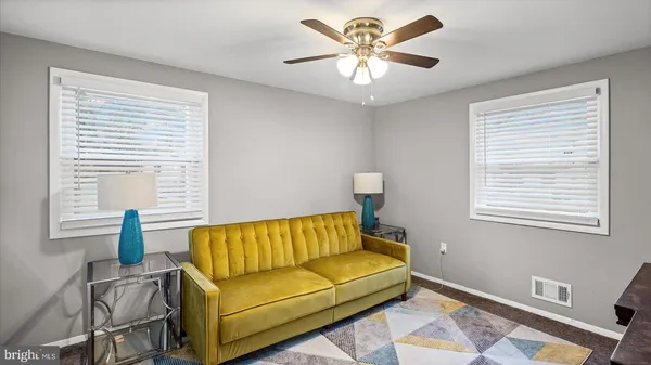 a living room with furniture a flat screen tv and a window