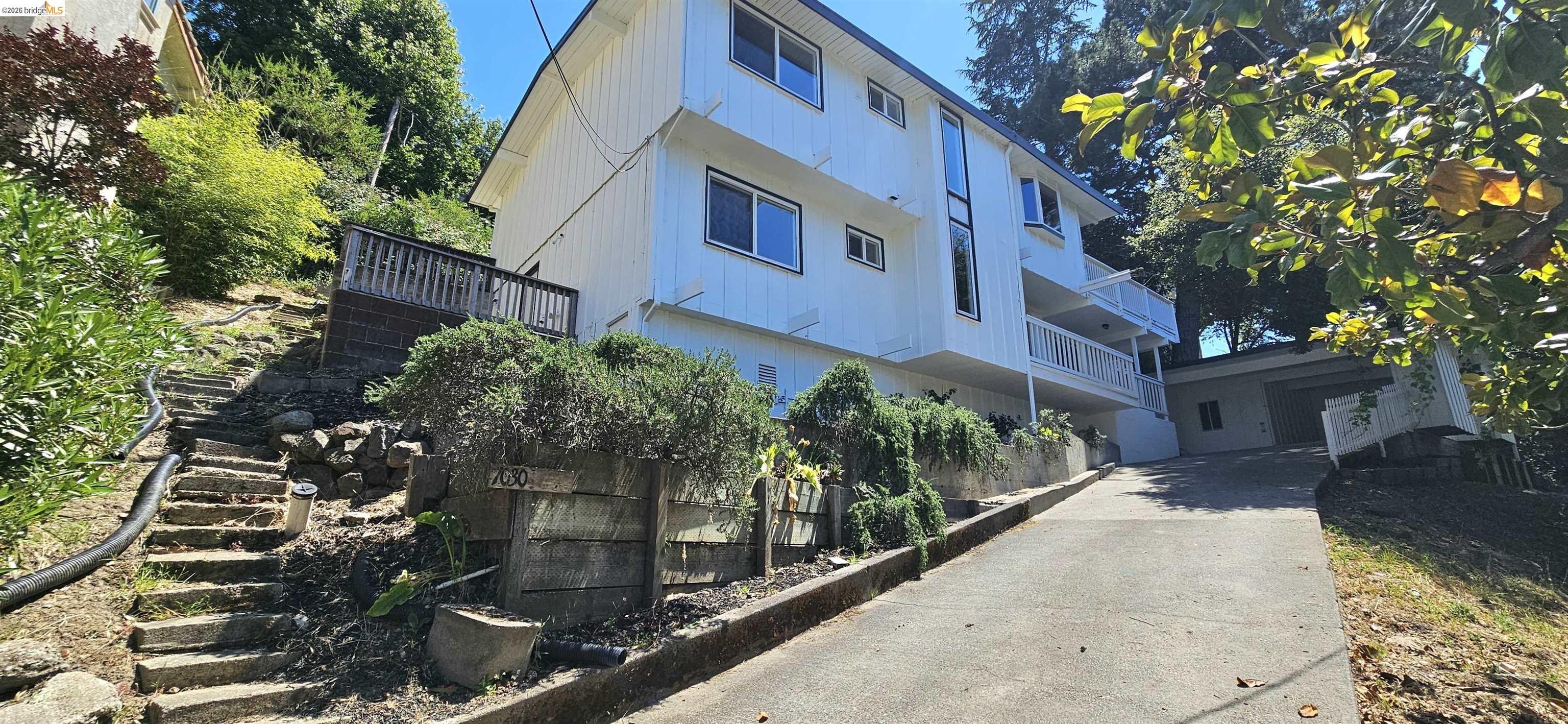 a view of a building with potted plants and large tree