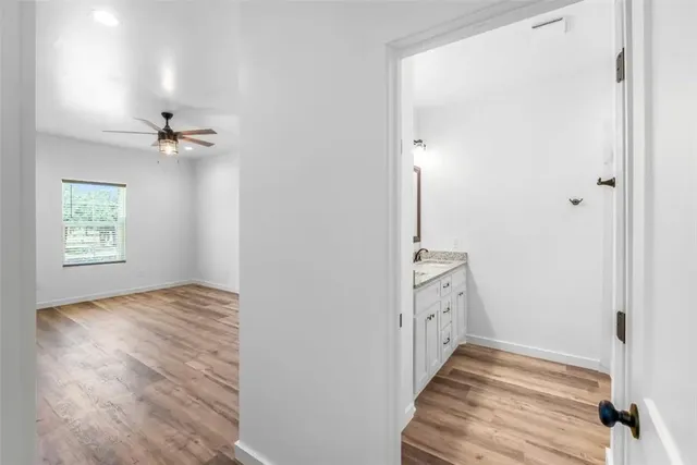 a view of an empty room with a window and a ceiling fan