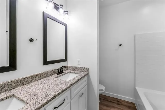a bathroom with a granite countertop sink toilet and shower