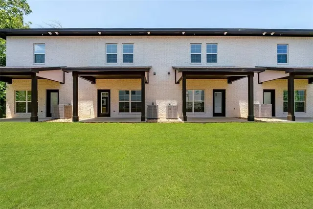 front view of a brick house with a yard