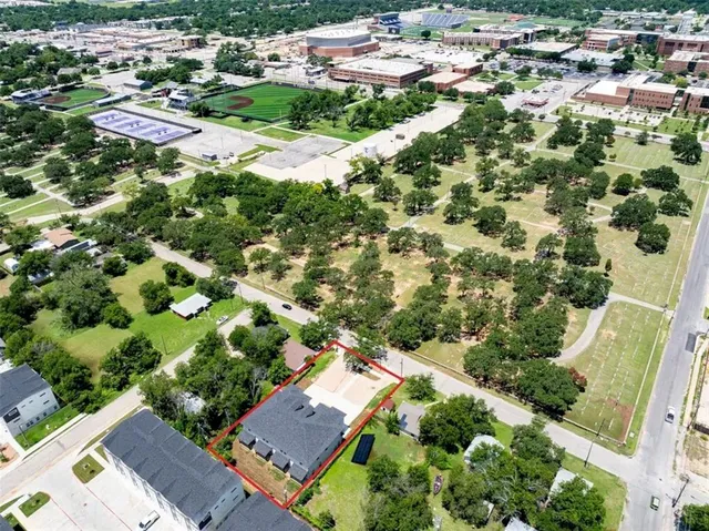 an aerial view of residential house with outdoor space and trees all around