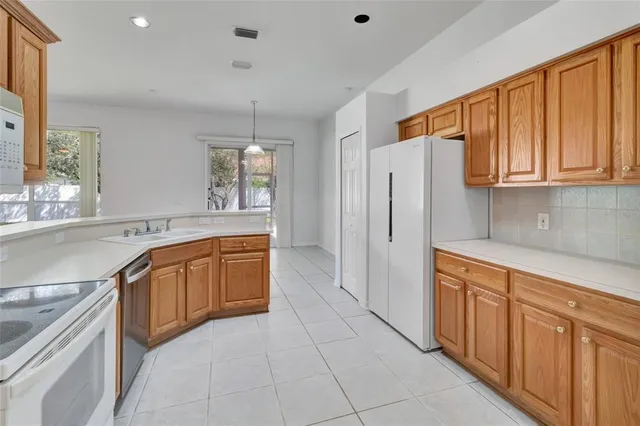 a large kitchen with stainless steel appliances granite countertop a refrigerator and a sink