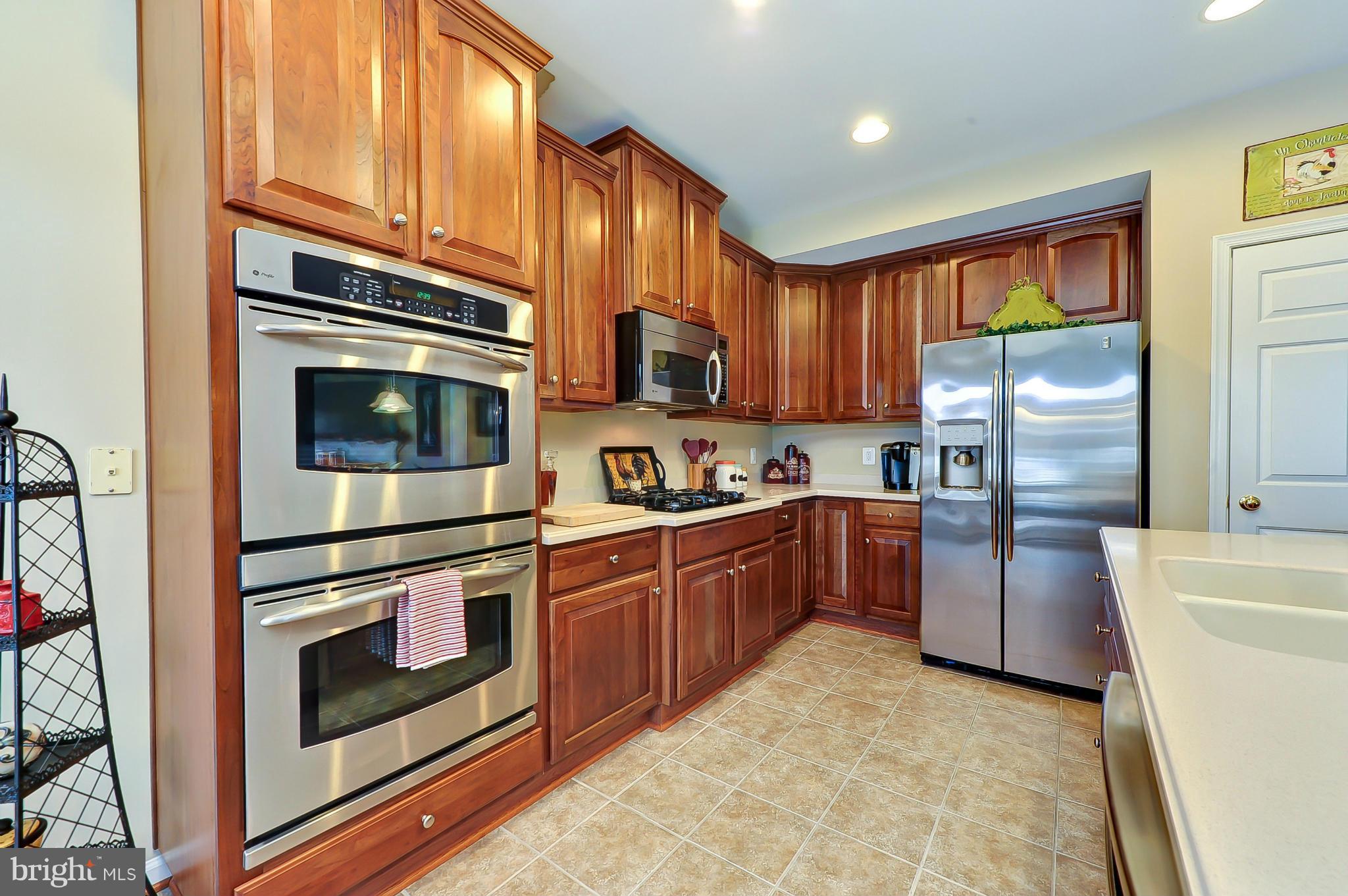 41888 Inspiration Terrace Aldie, VA 20105 - Photo 3 of 30 a kitchen with stainless steel appliances granite countertop a refrigerator a stove top oven a sink and dishwasher