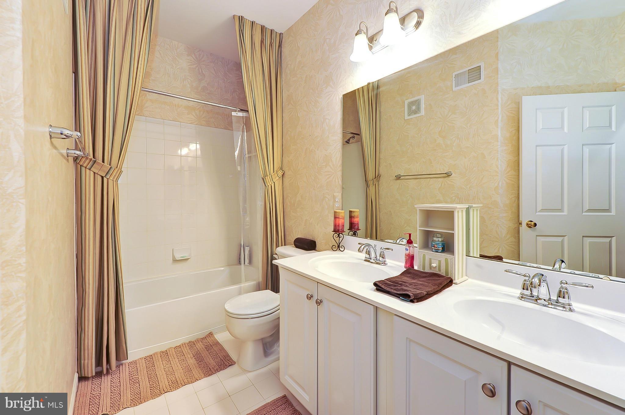 41888 Inspiration Terrace Aldie, VA 20105 - Photo 29 of 30 a bathroom with a double vanity sink toilet and shower