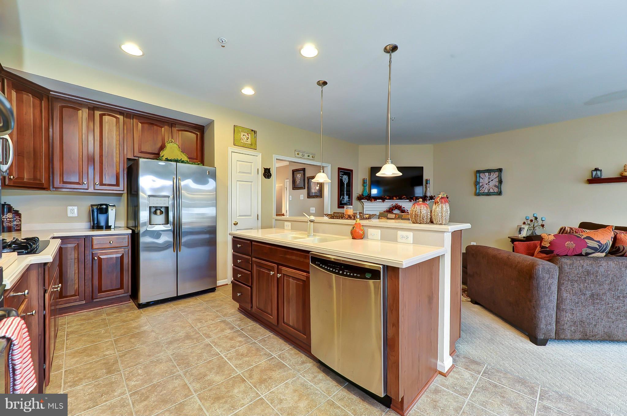 41888 Inspiration Terrace Aldie, VA 20105 - Photo 5 of 30 a kitchen with stainless steel appliances granite countertop a sink a stove and a refrigerator