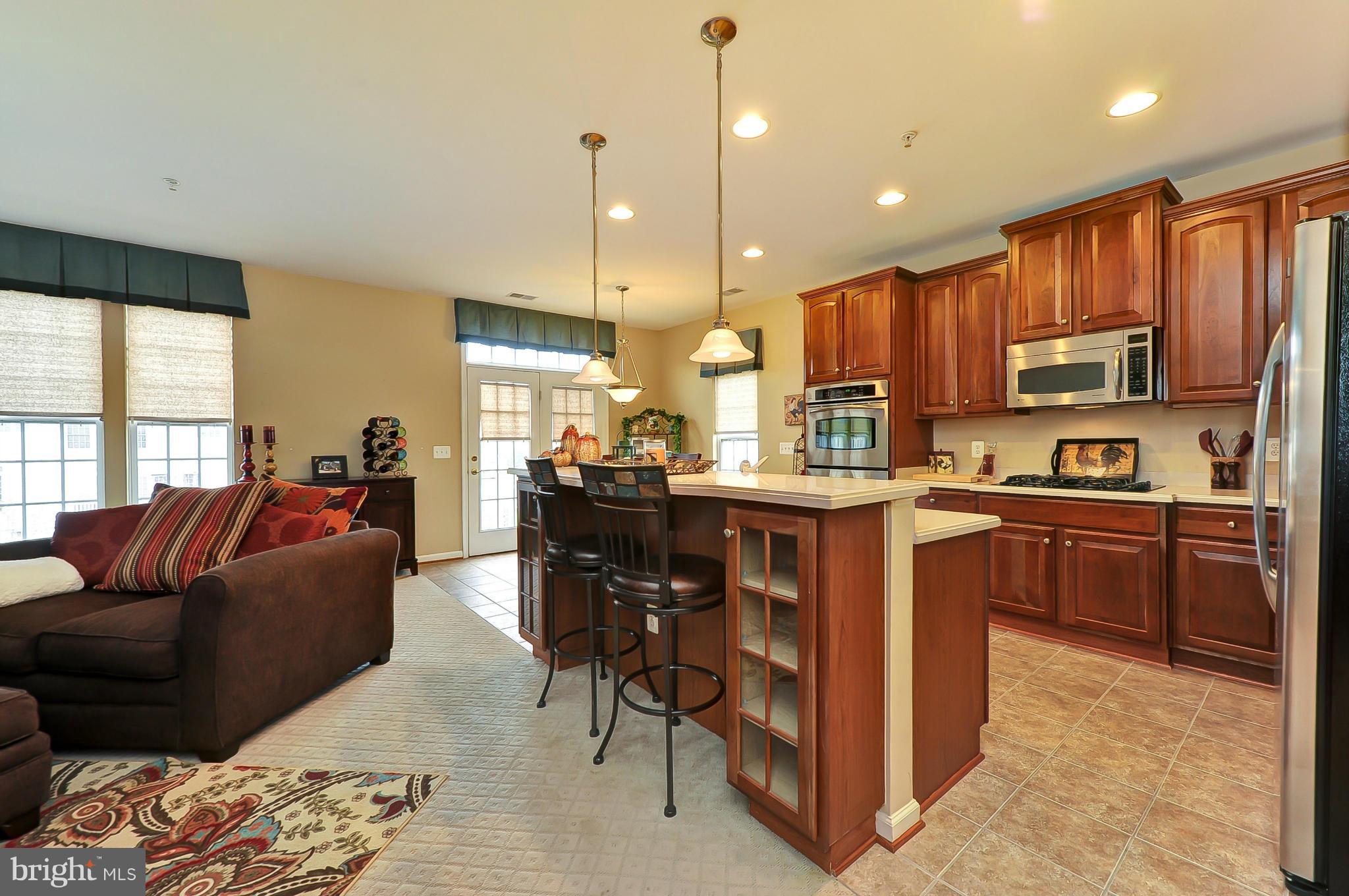 41888 Inspiration Terrace Aldie, VA 20105 - Photo 6 of 30 a living room with stainless steel appliances kitchen island granite countertop a refrigerator a stove a sink dishwasher with a dining table and chairs