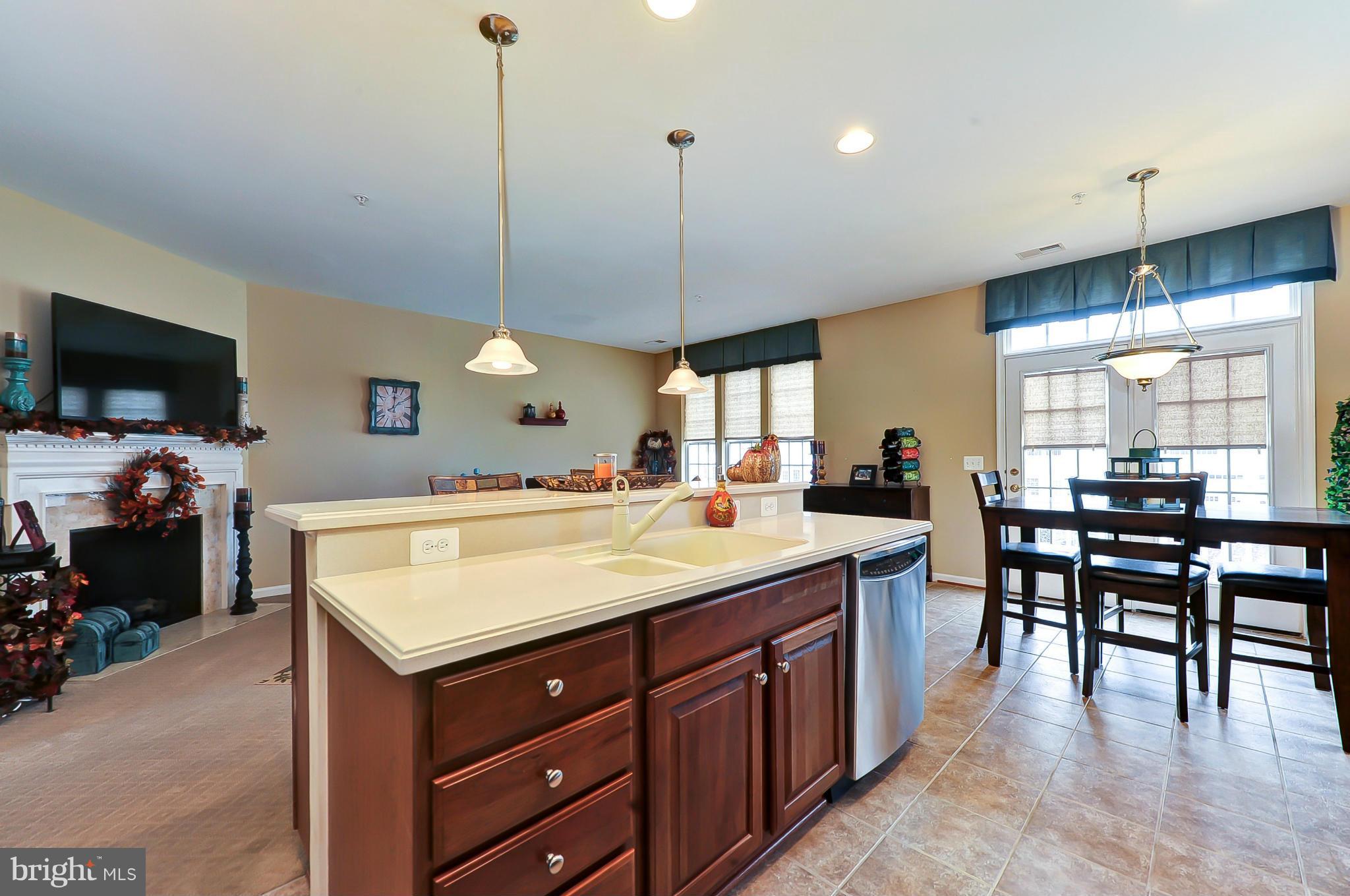 41888 Inspiration Terrace Aldie, VA 20105 - Photo 7 of 30 a large kitchen with kitchen island a stove a counter space dining table and chairs
