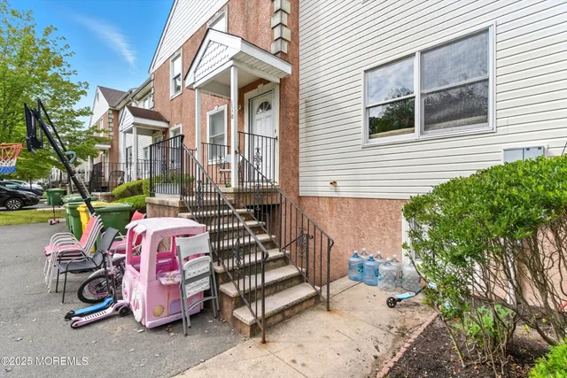 a view of a patio with a table and chairs and a barbeque