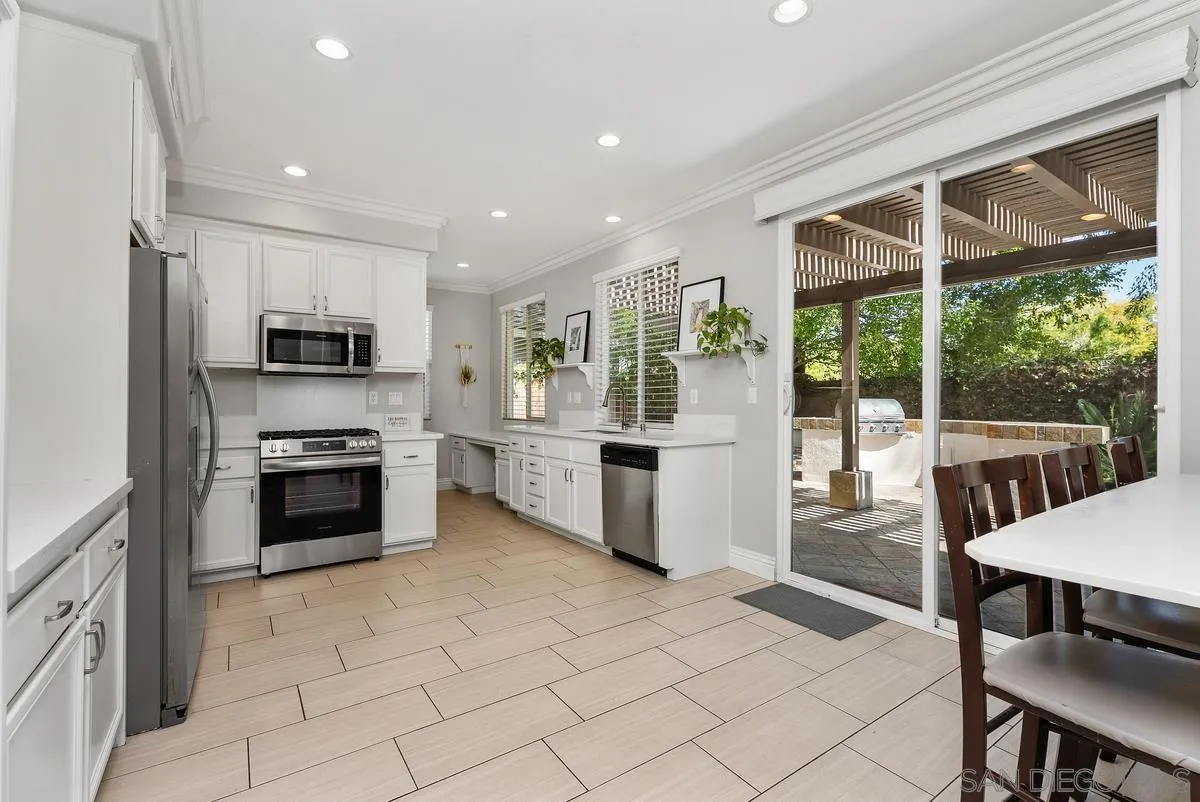 6 Reston Way Ladera Ranch, CA 92694 - Photo 7 of 39 a kitchen with stainless steel appliances granite countertop a stove a sink a microwave a dining table and chairs