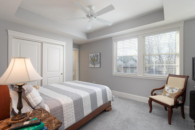 640 Wellner Road Naperville, IL 60540 - Photo 31 of 48 a bedroom with a bed and a chair
