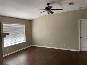 an empty room with a window and a fan