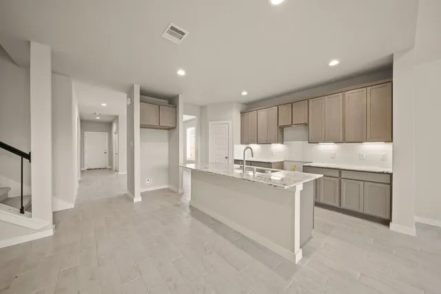 a kitchen with stainless steel appliances granite countertop a refrigerator and a sink