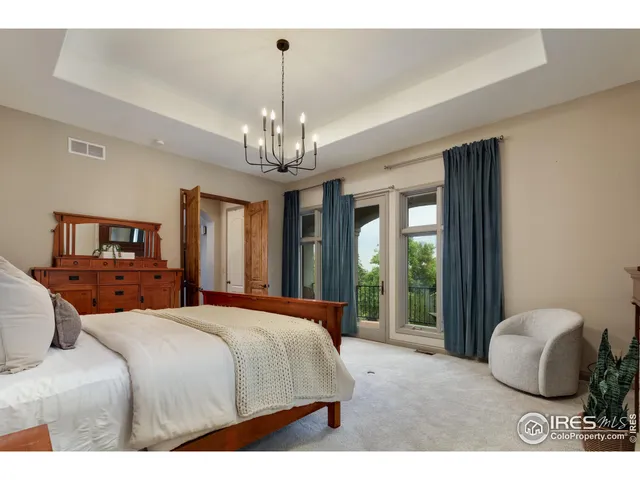 a bedroom with a large bed and a chandelier
